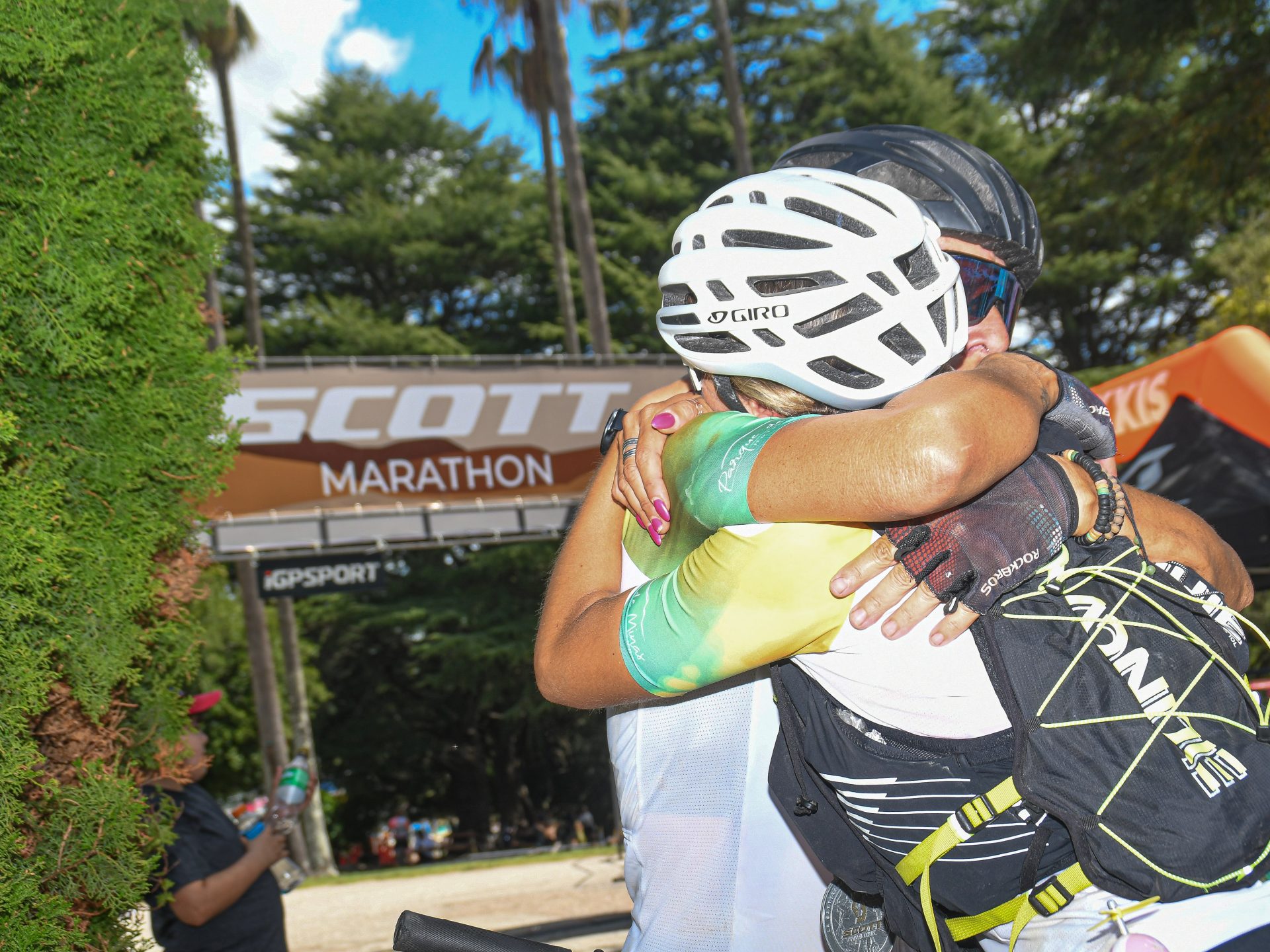 Ciclistas abrazándose bajo el arco de llegada de la Scott Marathon
